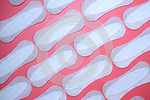 Flat lay pattern of clean unused sanitary woman pads on pink background