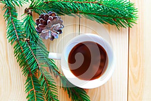 Flat lay photo with coffee cup, spruce branches and Christmas decorations on white wooden background.