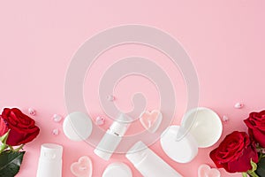 Flat lay photo of cosmetic bottles without label, red roses and heart shaped candles
