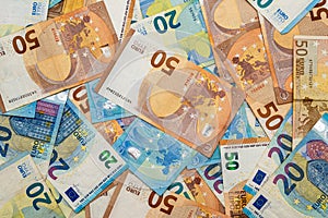 Flat lay photo of a many chaotically lying twentys and fiftys euro banknotes photo