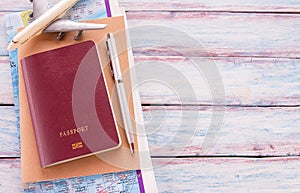 Flat lay photo with notebook, pen,map,passport and airplane on w