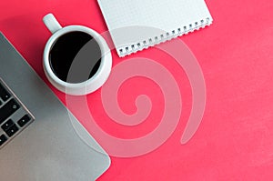 Flat lay photo of office desk with laptop, notebook and coffee