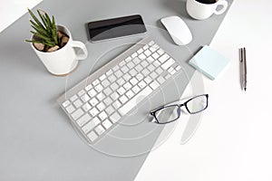 Flat lay photo of Office table with keyboard, notebook, digital tablet, mobile phone on modern two tone background