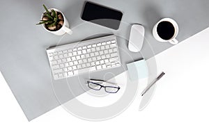 Flat lay photo of Office table with keyboard, notebook, digital tablet, mobile phone, Pencil, eyeglasses on modern two tone