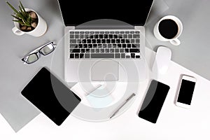 Flat lay photo of Office table with laptop computer, notebook, digital tablet, mobile phone on modern two tone background