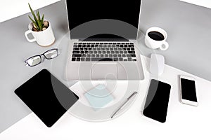 Flat lay photo of Office table with laptop computer, notebook, digital tablet, mobile phone on modern two tone background