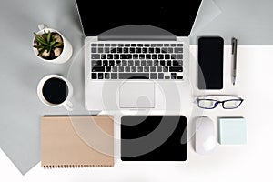 Flat lay photo of Office table with laptop computer, notebook, digital tablet, mobile phone on modern two tone background