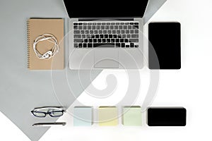 Flat lay photo of Office table with laptop computer, notebook, digital tablet, mobile phone on modern two tone background