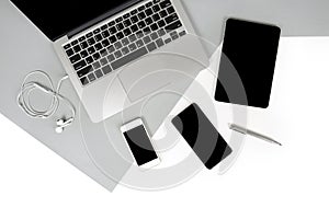 Flat lay photo of Office table with laptop computer, notebook, digital tablet, mobile phone on modern two tone background