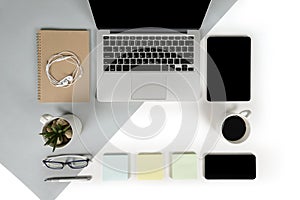 Flat lay photo of Office table with laptop computer, notebook, digital tablet, mobile phone on modern two tone background