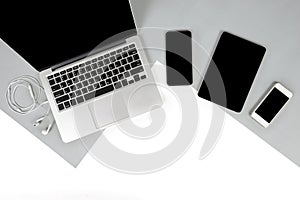 Flat lay photo of Office table with laptop computer, notebook, digital tablet, mobile phone on modern two tone background