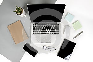 Flat lay photo of Office table with laptop computer, notebook, digital tablet, mobile phone on modern two tone background