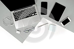 Flat lay photo of Office table with laptop computer, notebook, digital tablet, mobile phone on modern two tone background