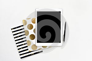 Flat lay photo of office white desk with tablet and gold notebook copy space background