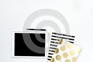 Flat lay photo of office white desk with tablet and gold notebook copy space background