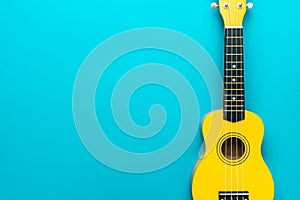Flat lay photo of yellow ukulele with copy space