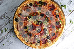 Flat lay photograph of tasty Italian pizza on grey rustic wooden background. Copy space banner.