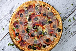 Flat lay photograph of tasty Italian pizza on grey rustic wooden background. Copy space banner.