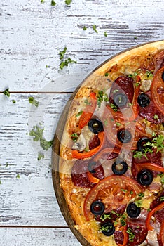 Flat lay photograph of tasty Italian pizza on grey rustic wooden background. Copy space banner.