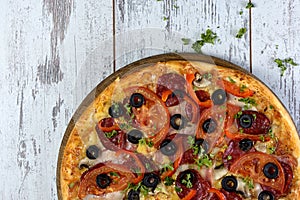 Flat lay photograph of tasty Italian pizza on grey rustic wooden background. Copy space banner.