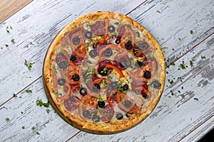 Flat lay photograph of tasty Italian pizza on grey rustic wooden background. Copy space banner.