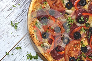 Flat lay photograph of tasty Italian pizza on grey rustic wooden background. Copy space banner