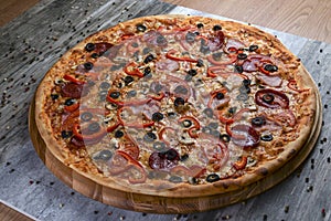 Flat lay photograph of tasty italian pizza on rustic wood. Pepperoni, cheese and peppers. Delicious food.