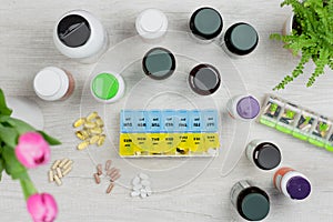 Flat lay with a pill holder and a variety of natural supplements