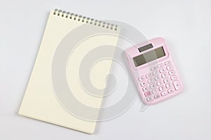 flat lay of pink calculator with blank page opened notebook. business and education concept