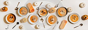 Flat-lay of pumpkin cream soup with sour cream, seeds, routons