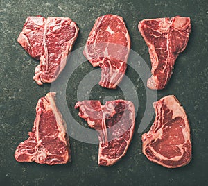 Flat-lay of raw beef meat steak cuts over black background