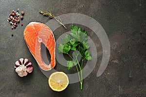 Flat lay raw salmon steak with spices and lemon on a dark rustic background. Healthy food. Top view, copy space