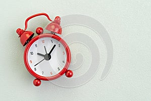 Flat lay of red alarm clock on texture white background with copy space using as time, deadline or schedule presentation wallpaper