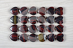 Flat lay red and iron tiger eye heart-shaped stones