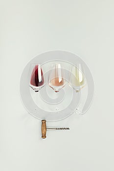 Flat-lay of red, rose and white wine in glasses on white background