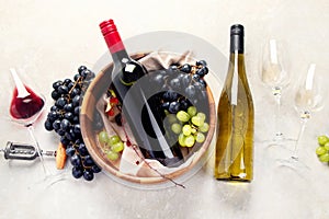 Flat-lay of red and white wine in glasses and corkscrews over grey concrete background, top view, copy space. Wine bar, winery,