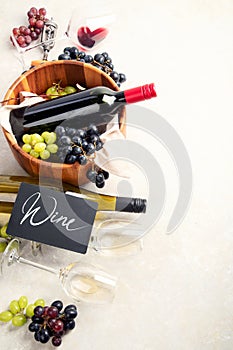 Flat-lay of red and white wine in glasses and corkscrews over grey concrete background, top view, copy space. Wine bar, winery,