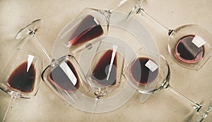 Flat-lay of red wine in glasses over grey concrete background