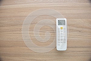Flat lay of the remote control of an air conditioner on a wooden surface