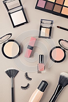 Flat lay with set of professional decorative cosmetics, makeup tools and woman accessories over gray background with copy space.