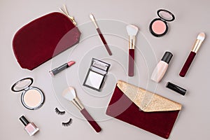 Flat lay with set of professional decorative cosmetics, makeup tools and woman accessories over gray background with copy space.