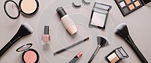 Flat lay with set of professional decorative cosmetics, makeup tools and woman accessories over gray background with copy space.