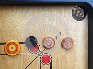 Flat lay shot a Carrom striker and carrom men balls on the carrom board. Play the game.Selective focus.