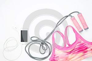 Flat lay of smartphone and sport equipments on white background