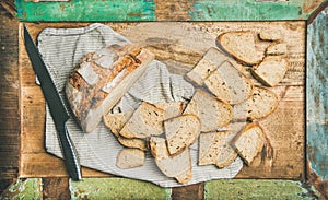 Flat-lay of sourdough wheat bread cut in slices in tray