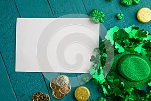 Flat lay, St. Patrick`s Day, white card for congratulation. March 17, on a green background with accesories for a celebration, a