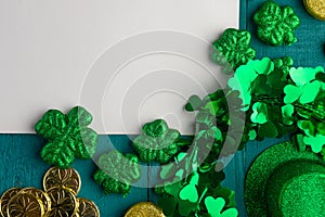 Flat lay, St. Patrick`s Day, white card for congratulation. March 17, on a green background with accesories for a celebration, a