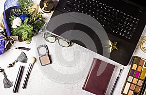 Flat lay styled office desk with laptop, winter bouquet with Nobilis pine branches, cosmetics, accessories