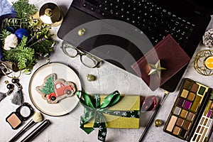 Flat lay styled office desk with laptop, winter bouquet with Nobilis pine branches, cosmetics, accessories