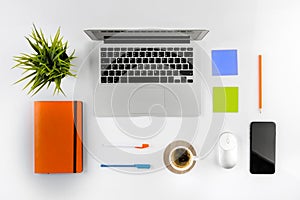 Flat lay styled photo of office desk with laptop, notebook and coffee